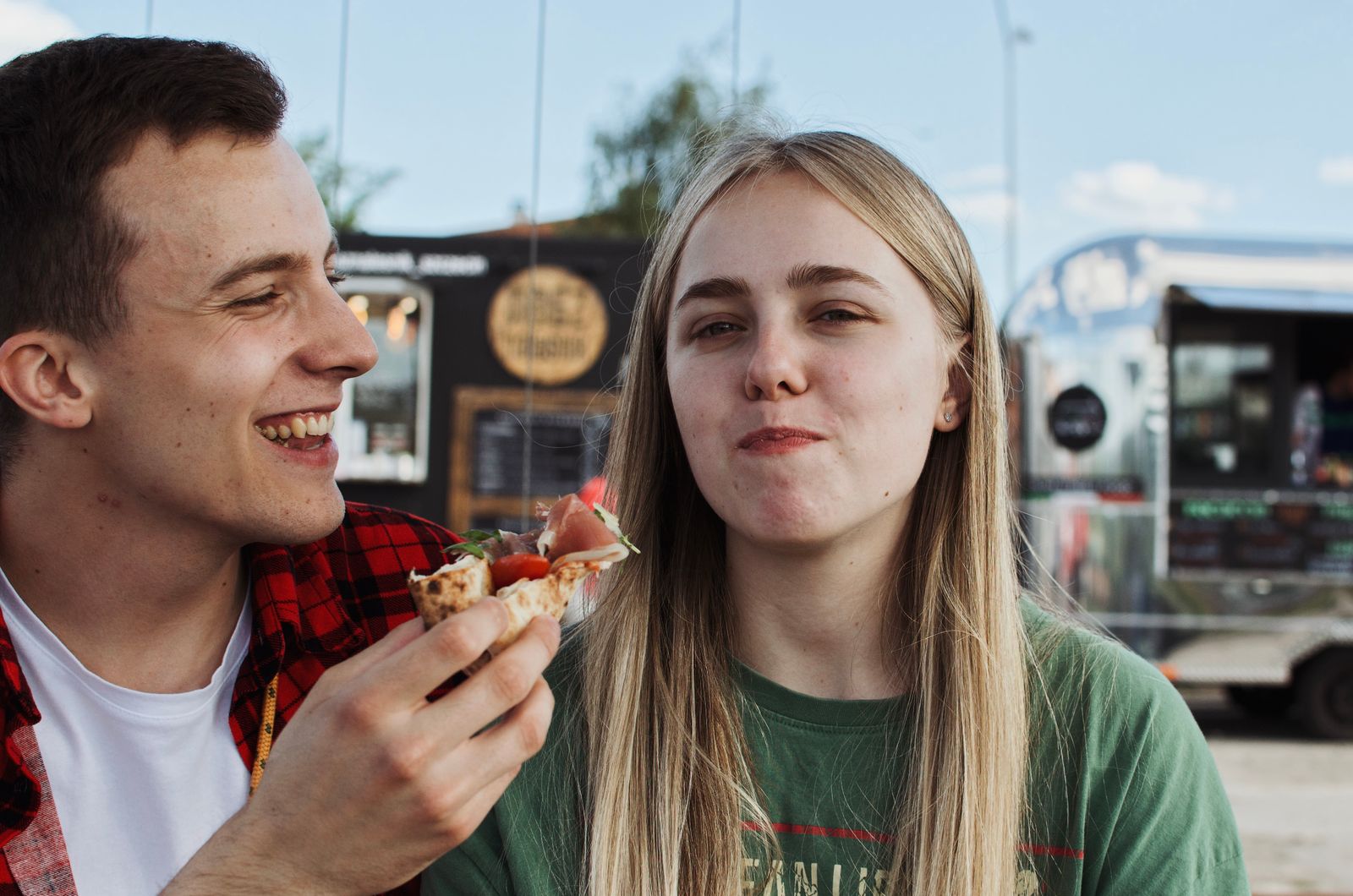 Couple eating street food in front of a food truck