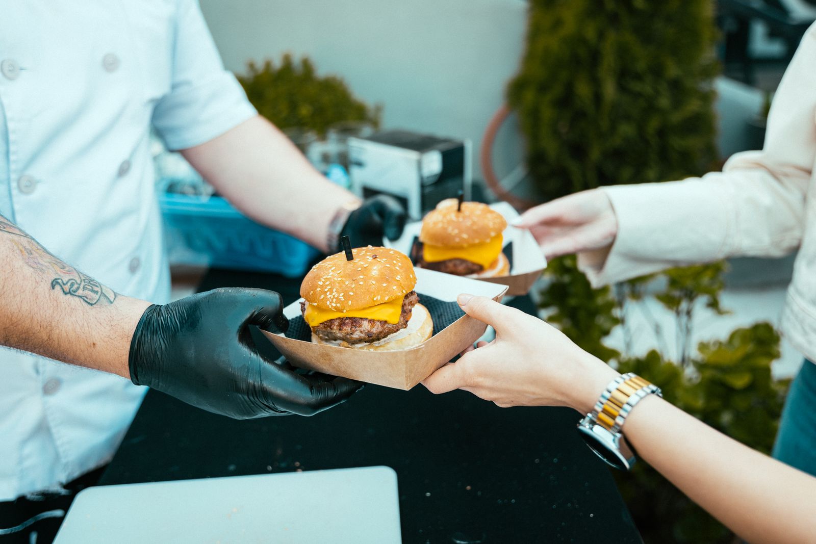 Food truck staff handing a burger over at the hatch