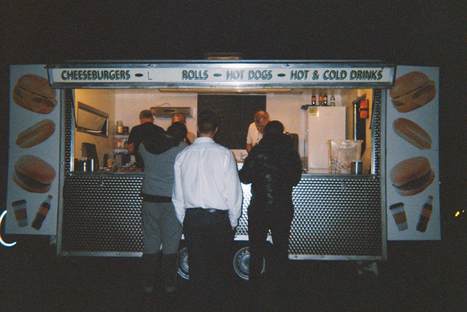 Customers queueing at a burger van at night