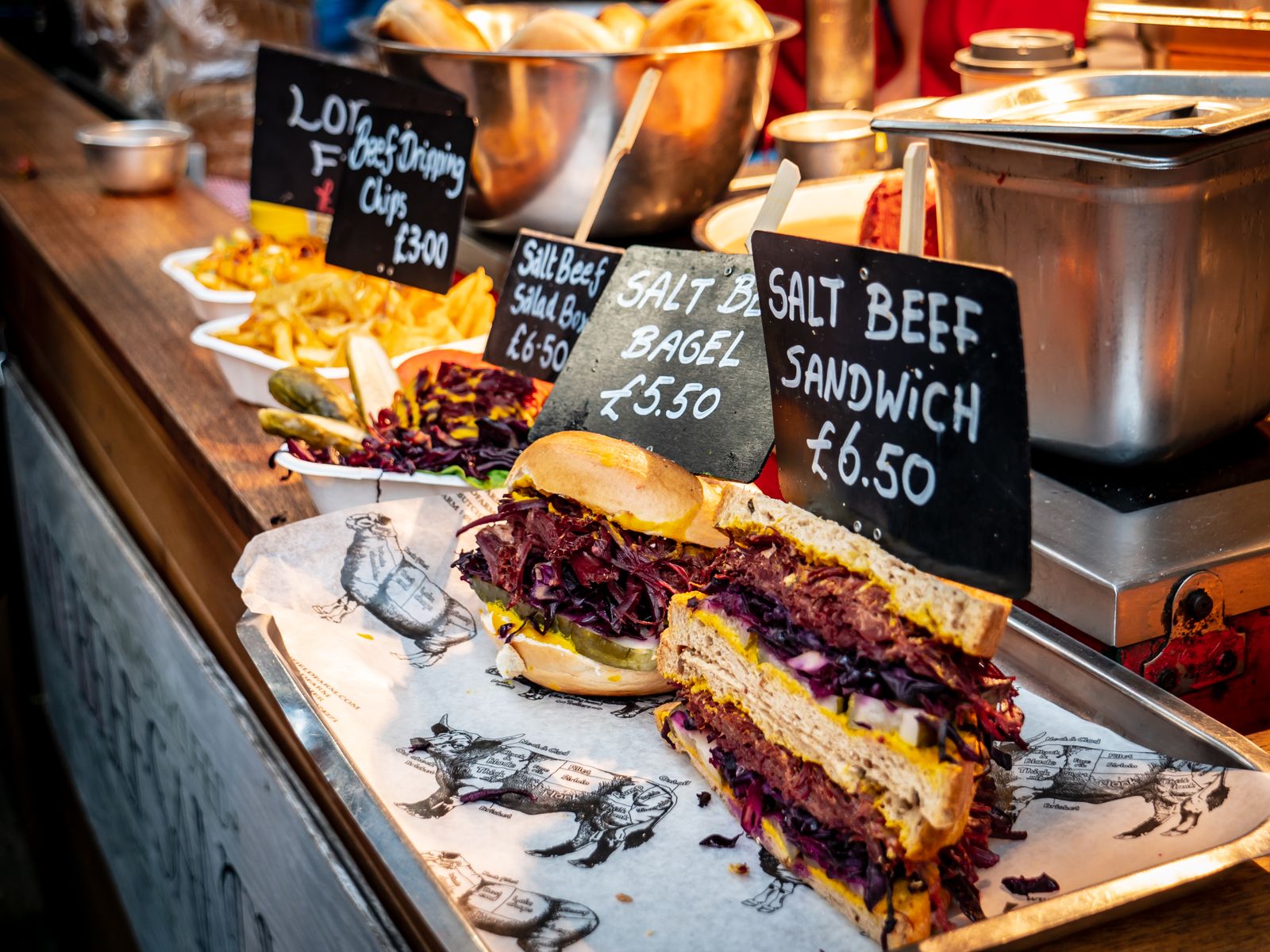 Street food stall with a hand-written salt beef sandwich price board
